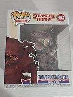 Front view of the new in box Stranger Things Tom/Bruce Monster Funko Pop! vinyl figure, showing the packaging number 903 and clear window display of the figure.