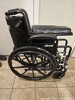 Side view of the Drive Silver Sport II wheelchair showing padded seat, large rear wheels and foldable frame.
