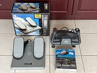Front view of CH Products Flight Simulator Yoke, Pro Pedals with original boxes, and boxed Microsoft Flight Simulator 2002 software displayed on tile floor against door background.
