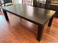 Table fully extended showing continuous dark veneer surface