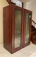 Full view of double door wine fridge with wood trim and glass doors showing interior racks and bottles inside.