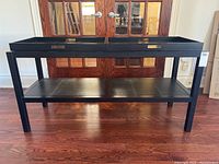 Dark espresso finished wood console table with two removable trays on top and a lower storage shelf.