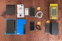 Image showing all items together including Nexus 7 tablet, hotspot devices, Samsung phones, and accessories on wooden floor