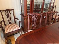 Three side chairs in front of china cabinet