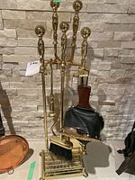 Full view of the brass fireplace tool set with shovel, broom, poker, log hook, tongs, bellows, and stand.