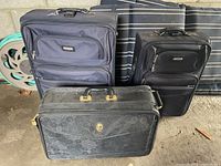 Three pieces of luggage including two matching Samboro cases and one DVF suitcase against a garage wall.