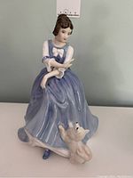 Front view of the Royal Doulton Lorraine porcelain figurine showing woman in blue dress with white dog at feet.