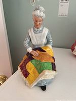 Front view of the Royal Doulton Eventide porcelain figurine showing the elderly woman quilting.