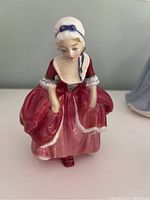 Front view of Royal Doulton Goody Two Shoes porcelain figurine highlighting dress and bonnet details.