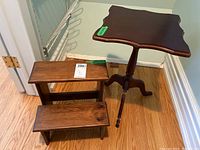 Side table and bed steps shown together on hardwood floor by corner wall.