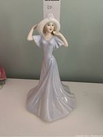 Front view of the Royal Doulton Chelsea Olivia HN 3717 porcelain figurine showing the delicate facial features, hat with pink rose detail, and flowing lavender gown.