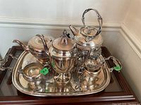 Full tea service set placed on the serving tray, showing all items together with reflective surfaces.