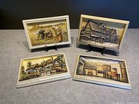 Four Ivorex 3D chalkware plaques displayed with detailed relief scenes of historical English cottages and rural themes.