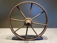 Front view of the antique cast iron wagon wheel showing the eight spokes and central hub.