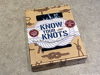 Front view of unopened Know Your Knots Kit in original packaging with box showing knot illustrations and clear window.