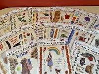 Photo shows 18 packages of new Paperhouse photographic stickers featuring various themes such as autumn, birthday, pets, Wizard of Oz, and travel, arranged spread out on a surface.