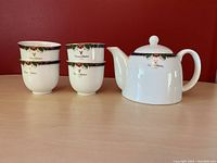 Set showing four teacups and teapot with floral, gold accents and Giovanni Valentino markings