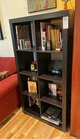 Front view of the bookcase filled with books and miscellaneous items, showing the size and cubby arrangement.