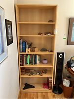 Frontal view of the bookcase showing all five shelves with various items on each shelf for scale and reference.