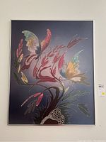 Full view of the butterfly print framed in metal with two butterflies and floral motifs on a blue-grey background.