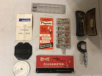 Full lot including plugometer, circular slide rule, micrometer, measuring cards, and other tools