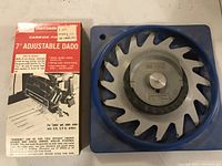 Photo of Craftsman 7 inch adjustable dado blade set in blue plastic holder with box showing product details including carbide tips and adjustment features.
