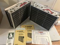 Two Honeywell electronic air cleaner units with manuals placed on a white surface.