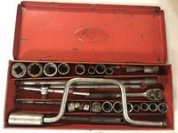 Open metal case showing organized socket set including ratchet, extension bars, and sockets