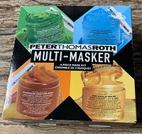 Box front with images of four jars showing different colored gels for each mask and brand labelling.