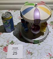 Top angled view showing colorful dome and multiple ride figures around the carousel.