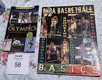 Photo showing front covers of two sports books: 'The Olympics' by Matt Christopher and 'NBA Basketball Basics' by Mark Vancil, placed side by side on a surface.