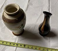 Photo showing Japanese Satsuma vase and Canadian pottery ewer side by side with measuring tape indicating size
