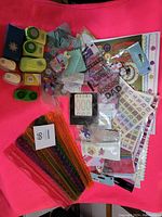 Overhead photo showing the entire craft lot with punches, paper rippers, stickers and decorative embellishments spread out on a pink background.