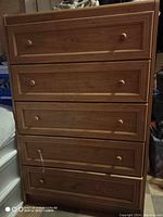 Front view showing five drawers with wooden knobs