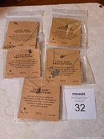 Photo showing five new necklaces in original packaging labeled 'Love and Protection'