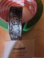 Close-up image of the Tibetan silver cuff bracelet showing the detailed floral and vine embossed pattern.