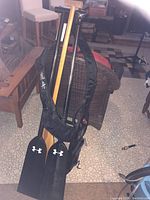 Photo showing three paddles and black paddle case standing upright on floor