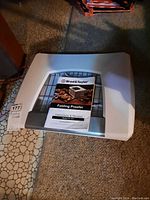 White Brod & Taylor folding proofer with instruction manual on top, placed on carpeted floor.