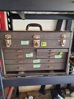 Front view of closed metal toolbox with labeled drawers