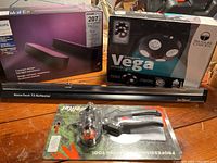 Photo showing boxed Philips Hue Play Light Bar kit, boxed Treasure Garden Vega rechargeable umbrella light, Sun Blaster NanoTech NanoTech TS Reflector light bar, and Wellkut BL132 grafting tool on card backing.