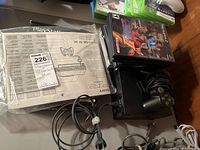 Overview of PlayStation 2 console with controller, games, and original manual