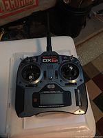 Front full view of Spektrum DX6i controller showing joysticks, switches, and antenna.