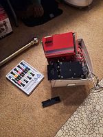 Overview of lot including red mini tool chest, box with cords, and precision screwdriver set on floor.