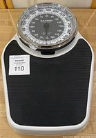 Full view of Salter Professional analog weight scale showing black textured standing platform and dial display.