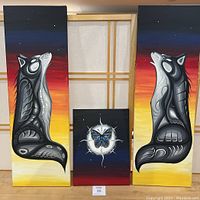Full view of the three paintings arranged together as a triptych, showing two tall wolf paintings on sides and a smaller butterfly painting in center.