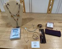 Full lot on table showing 5 necklaces on bust and laid out, 3 bracelets, chain bookmark, and pouch