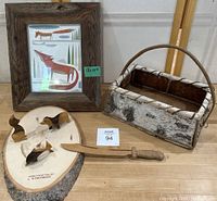 Overall lot showing framed wooden decor with stylized animal artwork, birch bark basket, wooden tree slice with carved animal figurines, and wooden sword.