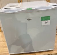 Front view of compact white Koolatron mini freezer with logo and lot tags visible.