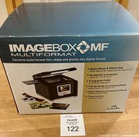Front of ImageBox MF scanner box showing key features including 35mm and 120mm film scanning, 9 megapixel CMOS sensor, 2.7" LCD, flip top design, Magic Touch dust and scratch removal, and TV-out.