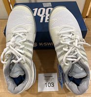 Top view of pair of size 9 K-Swiss white tennis shoes with box in background